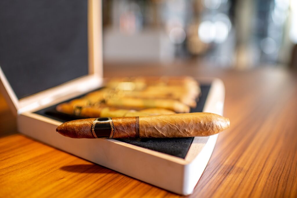 Exciting stocking stuffer ideas for men with cigars in a box on a wooden table.