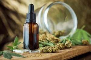 Cutting board with cannabis leaves and CBD oil, showcasing the importance of CBD education.