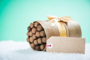 A wooden barrel with a gift tag in the snow, perfect for unique cigar gift ideas.