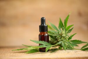 A wooden table displays a bottle of cbd oil, highlighting its health benefits.