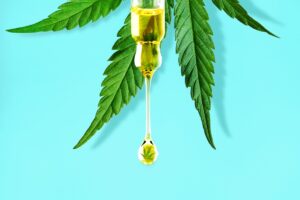 A syringe with a CBD oil leaf hanging from it, showcasing the latest advancements in CBD products.