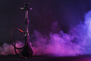 A hookah with flavors and smoke on a black background.