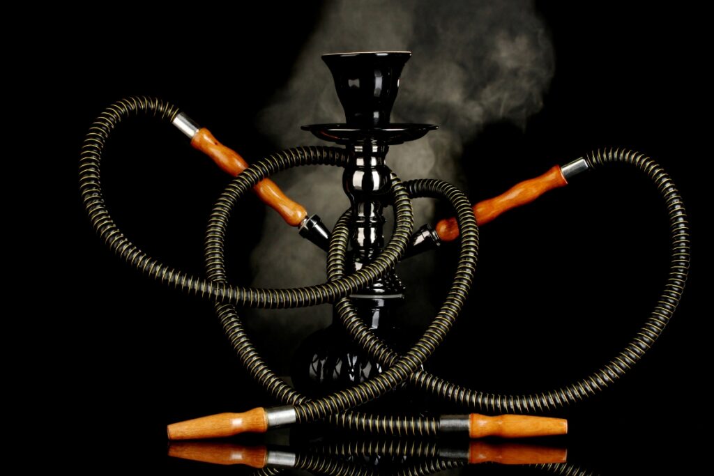 A hookah with two hoses and various flavors on a black background.