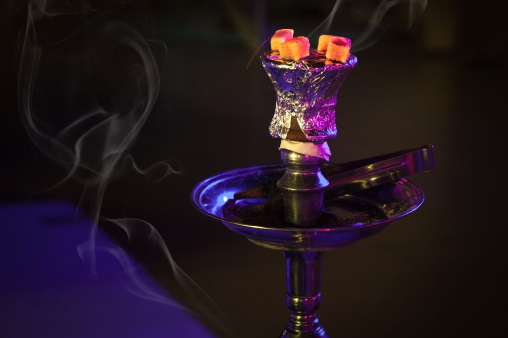 A hookah with smoke coming out of it, offering various flavors.