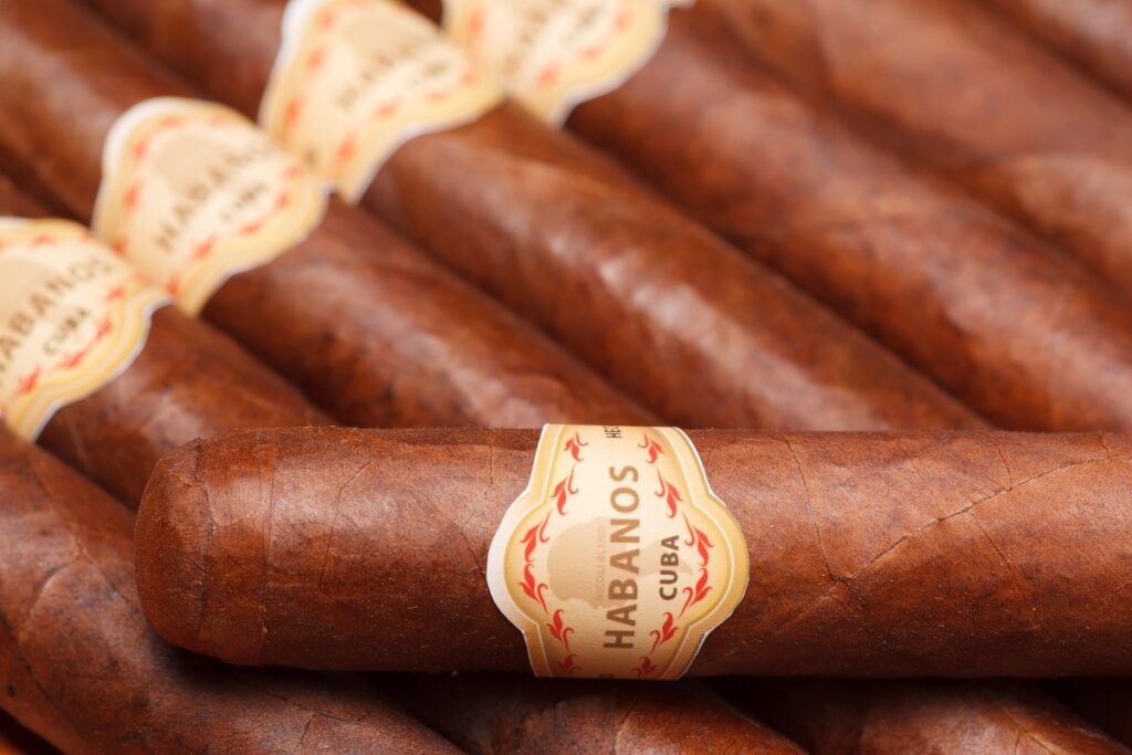 Close-up of a pile of Cuban cigars steeped in tobacco history, with a prominent "Habanos" label.