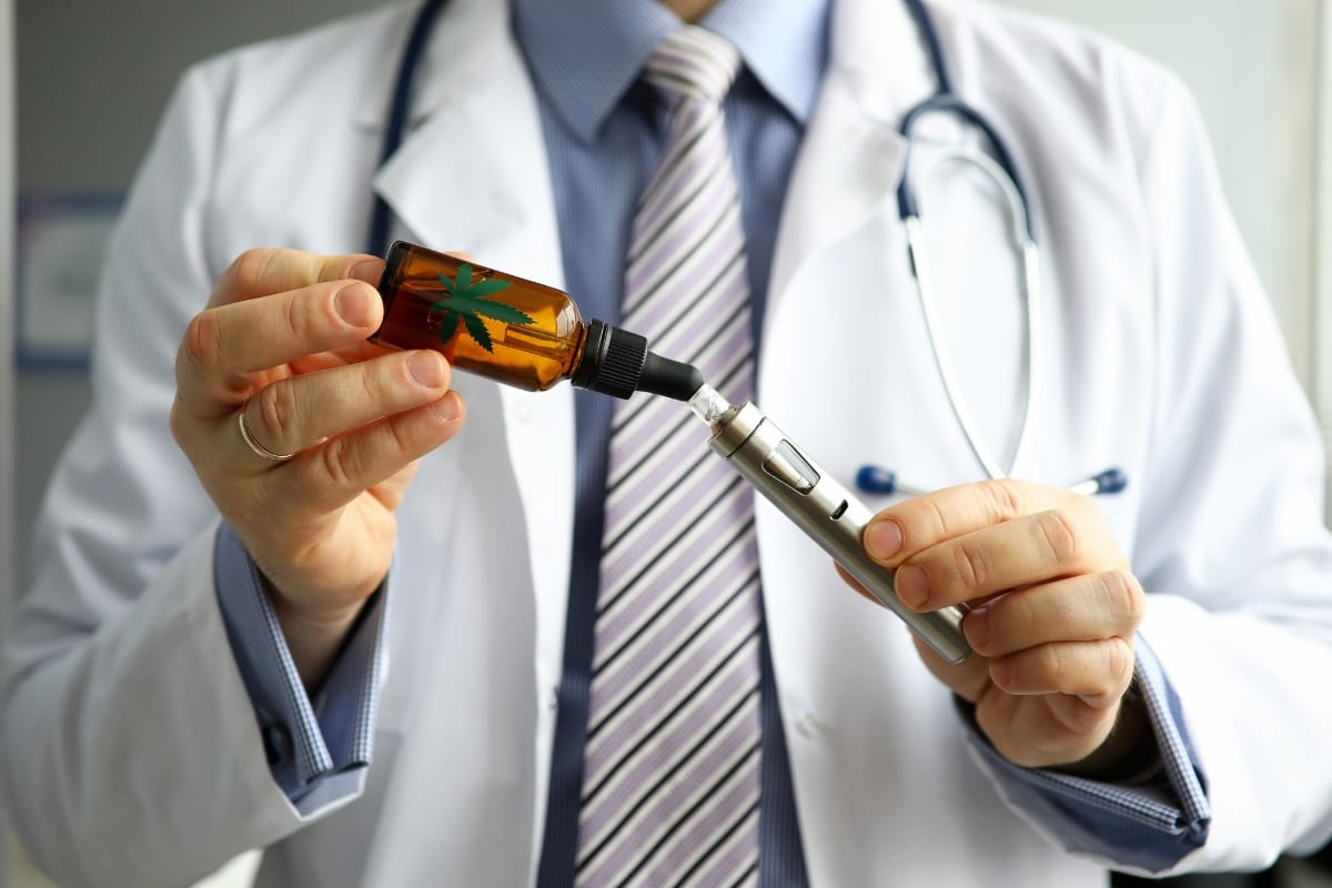 A doctor holds a dropper bottle adorned with a cannabis leaf symbol and a cbd vape pen, showcasing the blend of traditional medicine and modern wellness trends.